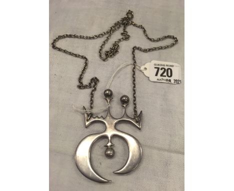 AN UNUSUAL SILVER PENDANT ON A LONG CHAIN