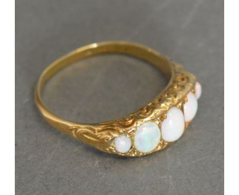 An 18ct. Yellow Gold Opal Set Ring with five graduated opals within an engraved setting