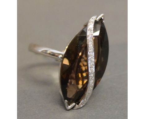 An 18ct. White Gold Citrine and Diamond Ring set with large navette shaped citrine cross with a wave of diamonds within a pie