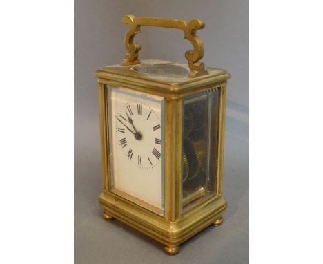 A Brass Cased Carriage Clock, the enamel dial with Roman numerals and with shaped carrying handle and visible escapement, ret