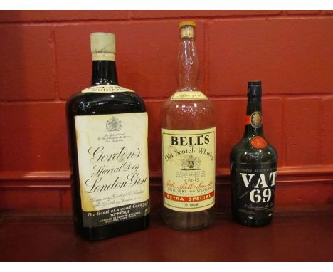 Three vintage spirit display bottles of large proportions, including Gordons Special Dry London Gin and Bells Scotch Whisky 