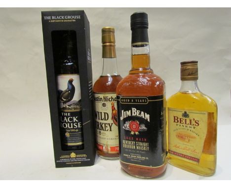 Four bottles of spirits including Jim Beam sour mash bourbon whiskey, Wild Turkey Old No 8 Brand, The Black Grouse scotch whi
