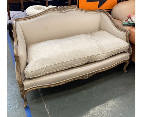 A two seater sofa in Louis XV style, 20th century, carved and painted frame, upholstered in a moire silk, with feather filled