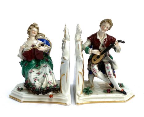 A pair of Continental Capodimonte porcelain figures/bookends, a lady reading and a gentleman playing a lute, in 18th century 