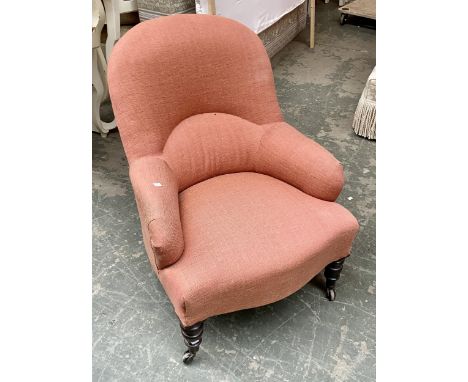 A 19th century bedroom chair, upholstered in red fabric with turned front legs and ceramic castors