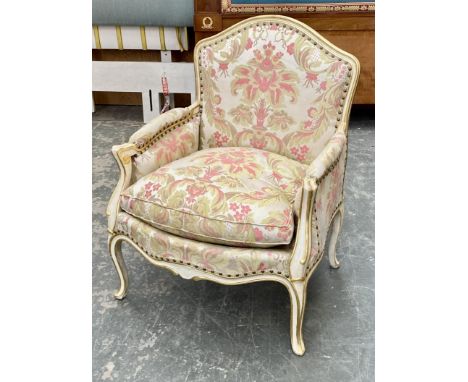 A painted and parcel gilt armchair in Louis VX taste, upholstered in a floral print with loose cushion, carved frame and cabr