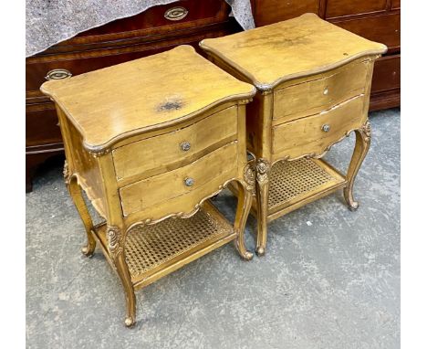 A pair of gilt gesso bedside cabinets, 20th century, each with serpentine shaped top, over two drawers, floral capped cabriol