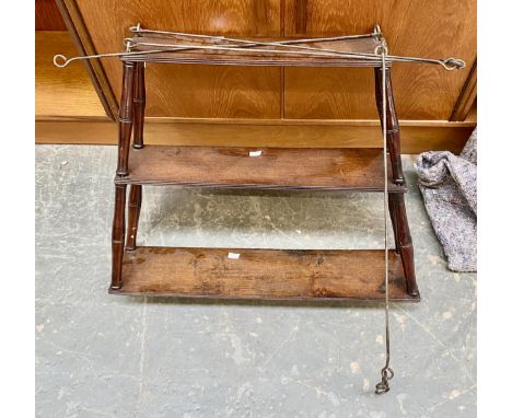 A three tier hanging shelf with turned supports, 62cmW at base