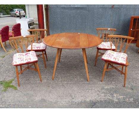 An Ercol drop-leaf Elm dining Table with four chairs being Elm and Beech having crossed stick back style backs complete with 