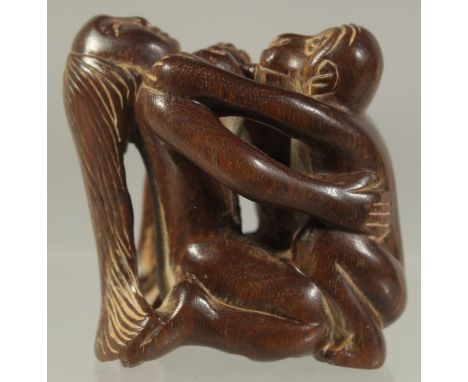 A CHINESE CARVED WOOD EROTIC NETSUKE. Signed.