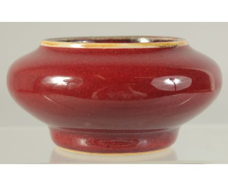 A CHINESE OX BLOOD GLAZE PORCELAIN BRUSH WASHER. 9cm diameter.