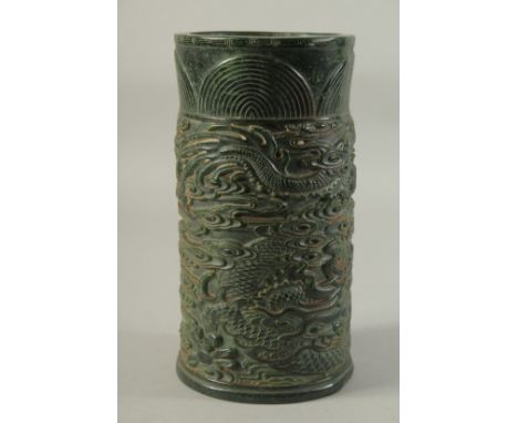 A LARGE CHINESE CARVED JADE CIRCULAR BRUSH POT, carved with dragons. 10ins high.