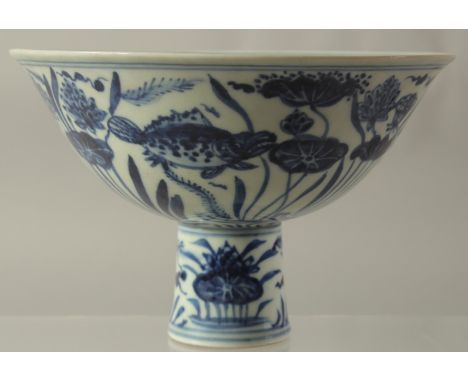 A CHINESE PORCELAIN BLUE AND WHITE STEM CUP painted with fish. 6.5ins high.