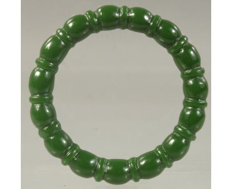 A CHINESE CARVED GREEN JADE BANGLE. 2.75ins