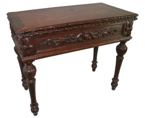 A 19th century oak fold over card table, the swivelling top with carved edge opening to reveal a storage well with metal plaq