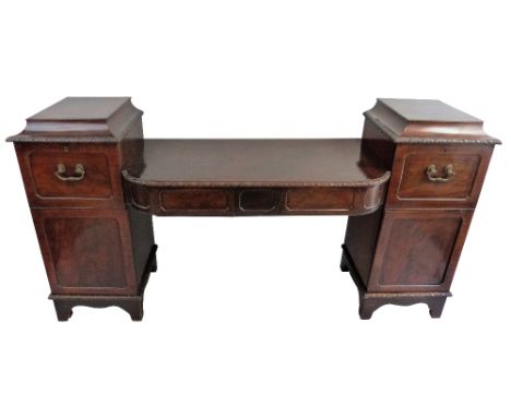 A William IV mahogany pedestal sideboard, of break front form with a split level top, each pedestal with carved edges to the 