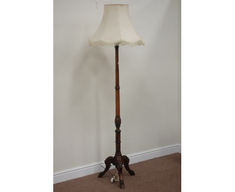 Walnut standard lamp, raised on triple splay legs with carved knees and hairy hooves
