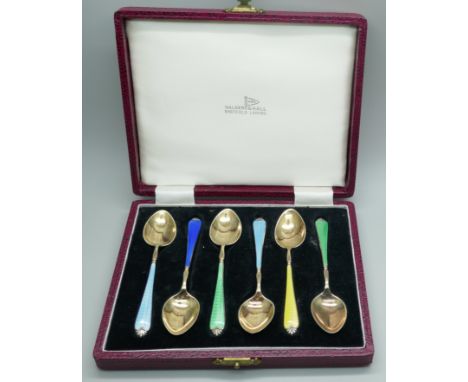 A cased set of six silver gilt and enamel spoons, by Adie Bros., in a Walker &amp; Hall box, enamel on four a/f