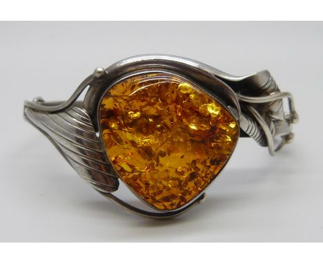 An Art Nouveau style silver and amber bangle, 31g