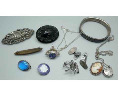 A jet brooch, a white metal bangle with enamel and seed pearl design, a silver swivel fob, a Victorian mourning brooch, a sil