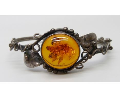 An Art Nouveau style silver and amber bangle, 14g