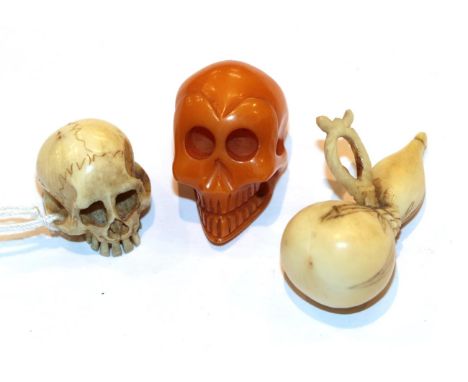 Japanese ivory netsuke as a skull, 2cm high, another as a gourd and an amber skull, 2.3cm high (3) .  Ivory - 12g total weigh