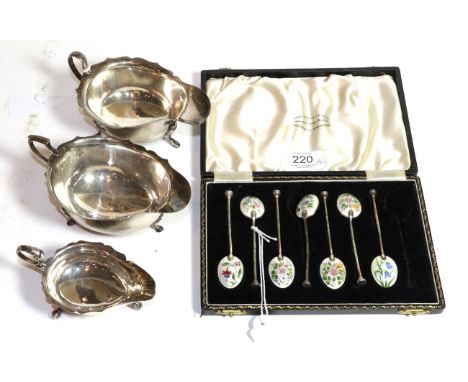 A set of seven George VI silver and enamel teaspoons, the bowl of each spoon enamelled with a differing flower, in case fitte