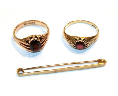 Two 9 carat gold garnet rings, finger sizes R and S and a 9 carat gold bar brooch .  Larger garnet ring - In good condition, 