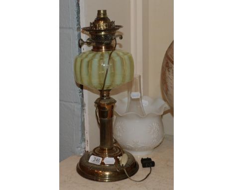 A Victorian oil lamp, opaque shade, iridescent striped glass reservoir, gilt brass base.  Minor chips to chimney, split to to