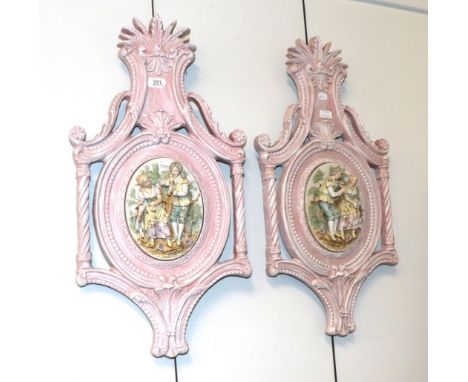 A pair of figural bisque pottery and carved wood wall plaques together with a pair of figural chargers (4)  