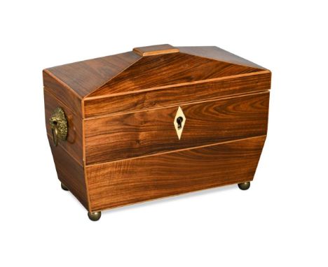A Regency rosewood tea caddy, of sarcophagus form, the hinged cover opening to reveal twin lidded compartments within, raised