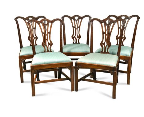 A set of five mahogany dining chairs, 19th century, the shaped top rails above vase shaped pierced splats with light blue uph