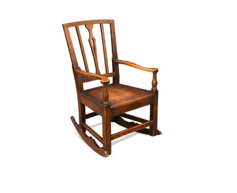 An elm country rocking chair, 19th century, the stick back with out scrolling arms supported by turned columns terminating on