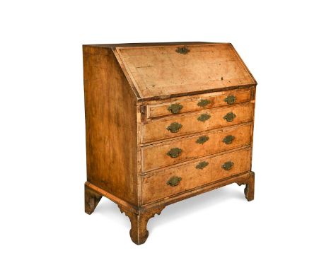 A George I walnut and feather banded bureau, the fall front enclosing a fitted interior of drawers and pigeon holes over four
