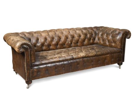 A Chesterfield sofa, late 19th/ early 20th century, upholstered in studded brown leather on squat bun front feet and square r