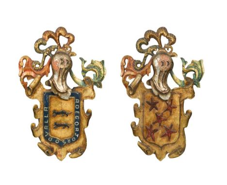A pair of carved and painted wooden coats of arms, late 19th / early 20th century, the first bearing a pair of black saber wo