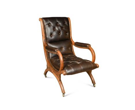 A Regency oak Spanish chair, in the manner of Gillows, with close button back brown leather upholstery104 x 63 x 80cmLiteratu