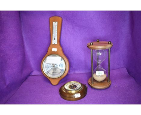 An egg timer and two barometers.