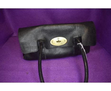 A leather handbag having shoulder strap and brass fitments