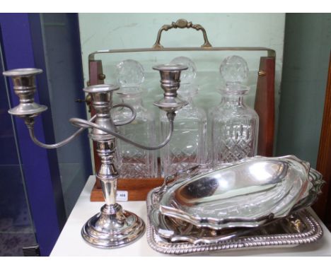 A three decanter tantalus, plated twin branch candelabra and various plated serving dishes