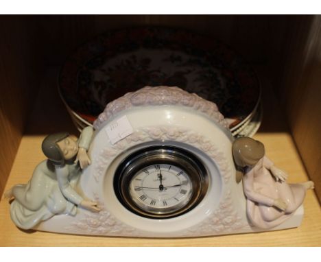 A Lladro mantel clock figure mounted, together with four decorative plates Condition: Lladro clock good, no chips or chips, p