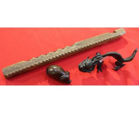 A cast bronze Chinese Dragon, together with a carved hardwood pig netsuke &amp; a carved wood flute (3)