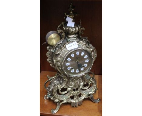 A reproduction French Rococo design brass mantle clock with Roman numerals