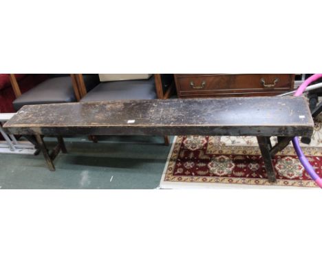 A black painted well worn vintage school style bench, with folding legs