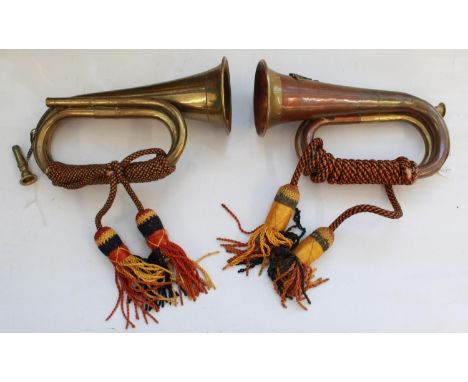Pair of military bugles. Both with mouth pieces, bugle cords and tassels, one with The Royal Artillery Crest