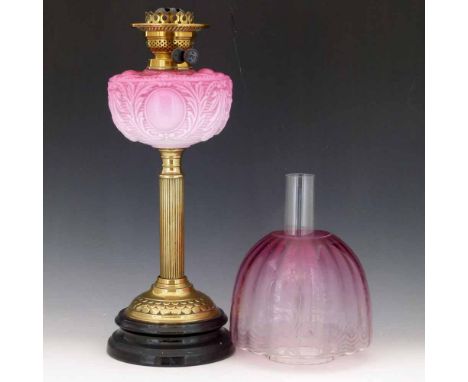 Victorian table oil lamp the moulded pink glass reservoir on a brass reeded column, height 48cm, with pink glass shade (crack