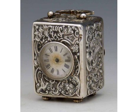 Silver cased miniature carriage clock by Wm Comyns, London 1895, embossed with rococo scrolls, fitted with a white enamel dia