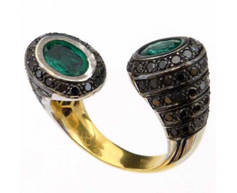 Modern design torc ring, set at either end with a cluster of an emerald surrounded by black diamonds, in bi-coloured 750 gold