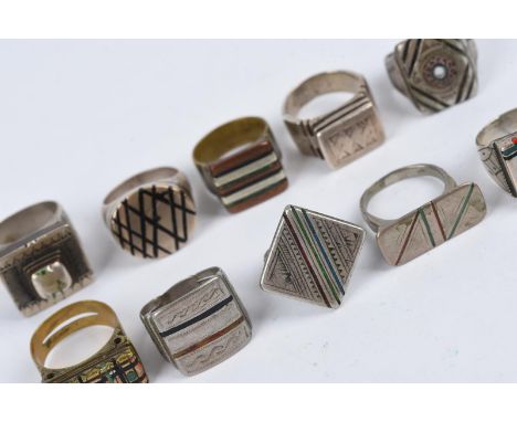 Ten Tuareg rings North Africa silver coloured metal and brass, eight with enamel lines and two with chevron beads, one with s