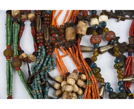Eight Himalayan bead necklaces glass, seed, brass, silver coloured metal, shell, bone, hung with pendants, including trumpets